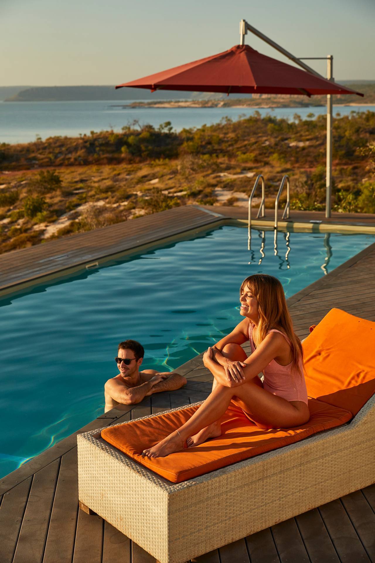 A woman on a lounger and a man in a pool