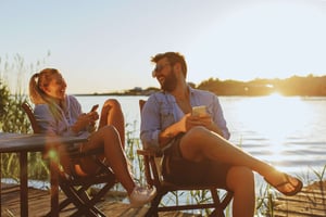 A couple sitting by the water in an outdoor environment