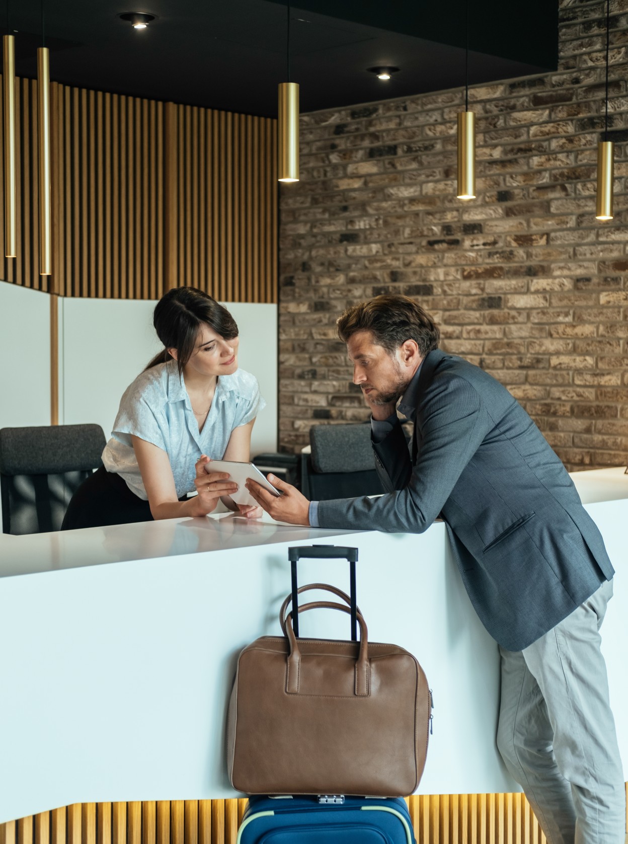 Man with suitcase checking in to a hotel