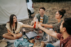 Photo of friends camping, hanging out together, social gathering.