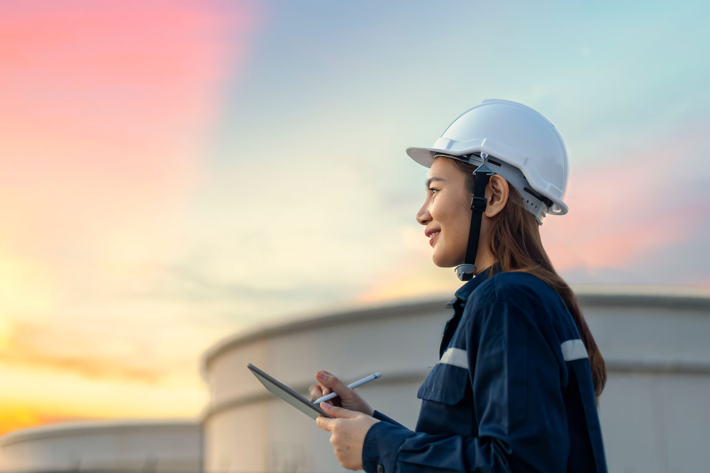 A worker with a white hard hat on and a clipping board