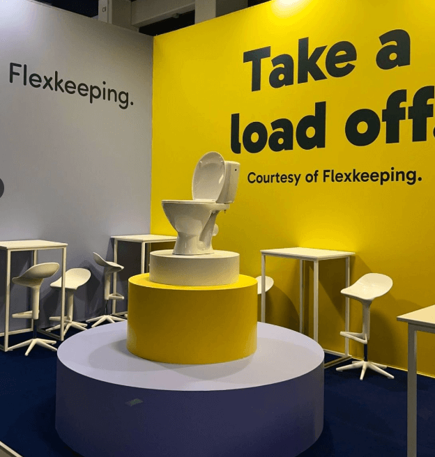 The Flexkeeping stand at ITB Berlin showing a big toilet on a yellow pedestal