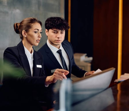 Two smartly dressed people looking at computer screen
