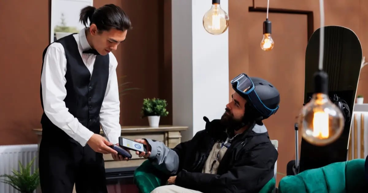 Hotel guest making a contactless payment using their phone to authorize the transaction.