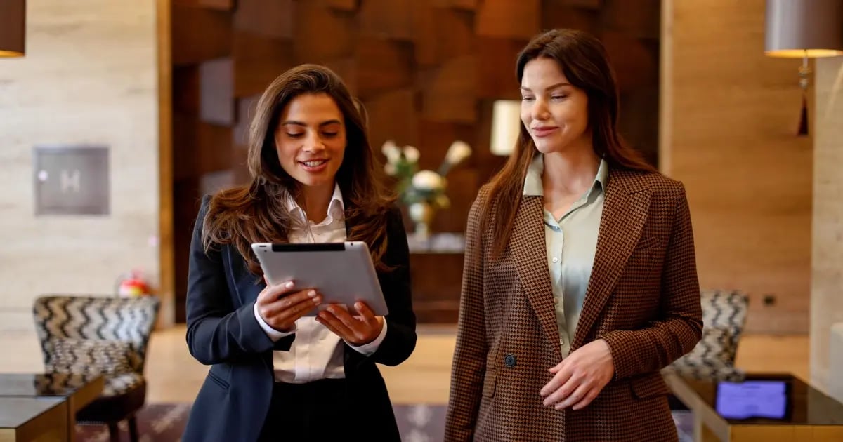 A hotel receptionist engrossed in her work as she makes an online reservation on a PC.