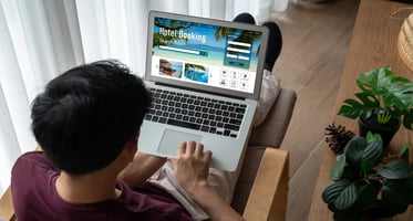 Person using a laptop to book hotel room from home.
