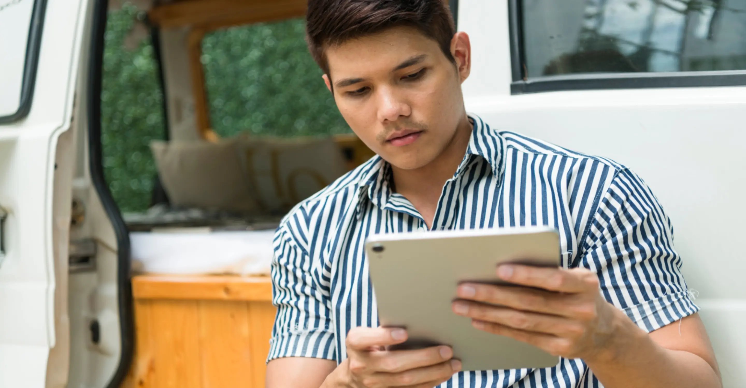Campground manager checking information on a tablet—demonstrating the convenience of using RMS when managing holiday park operations.