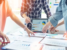 Hotel management group meeting to analyze and discuss financial performance and strategy.