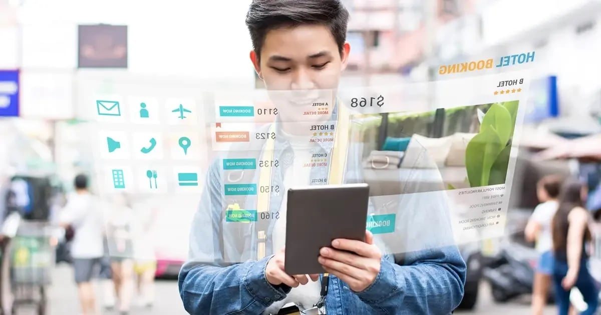 Image of a young man comparing hotel options on a tablet.
