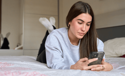 Woman on bed on device
