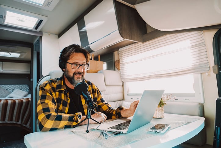 Man sitting in a caravan and recording a podcast