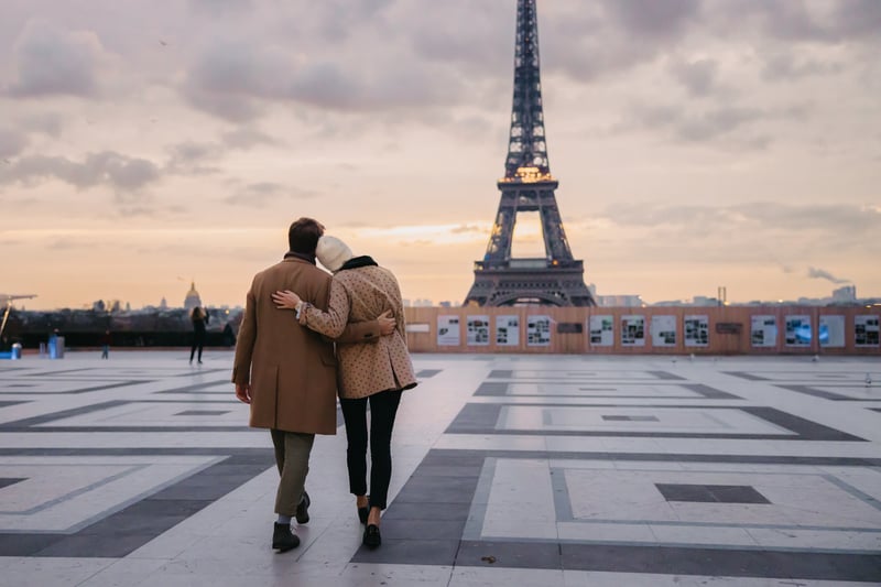 A couple walking in front of the Eiffel tower in Paris