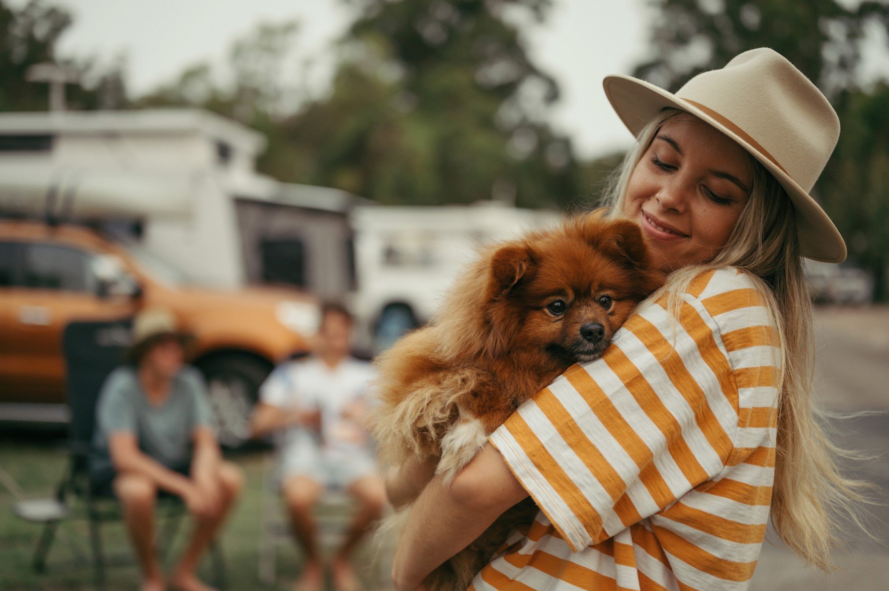 Young woman with a hat holding a dog