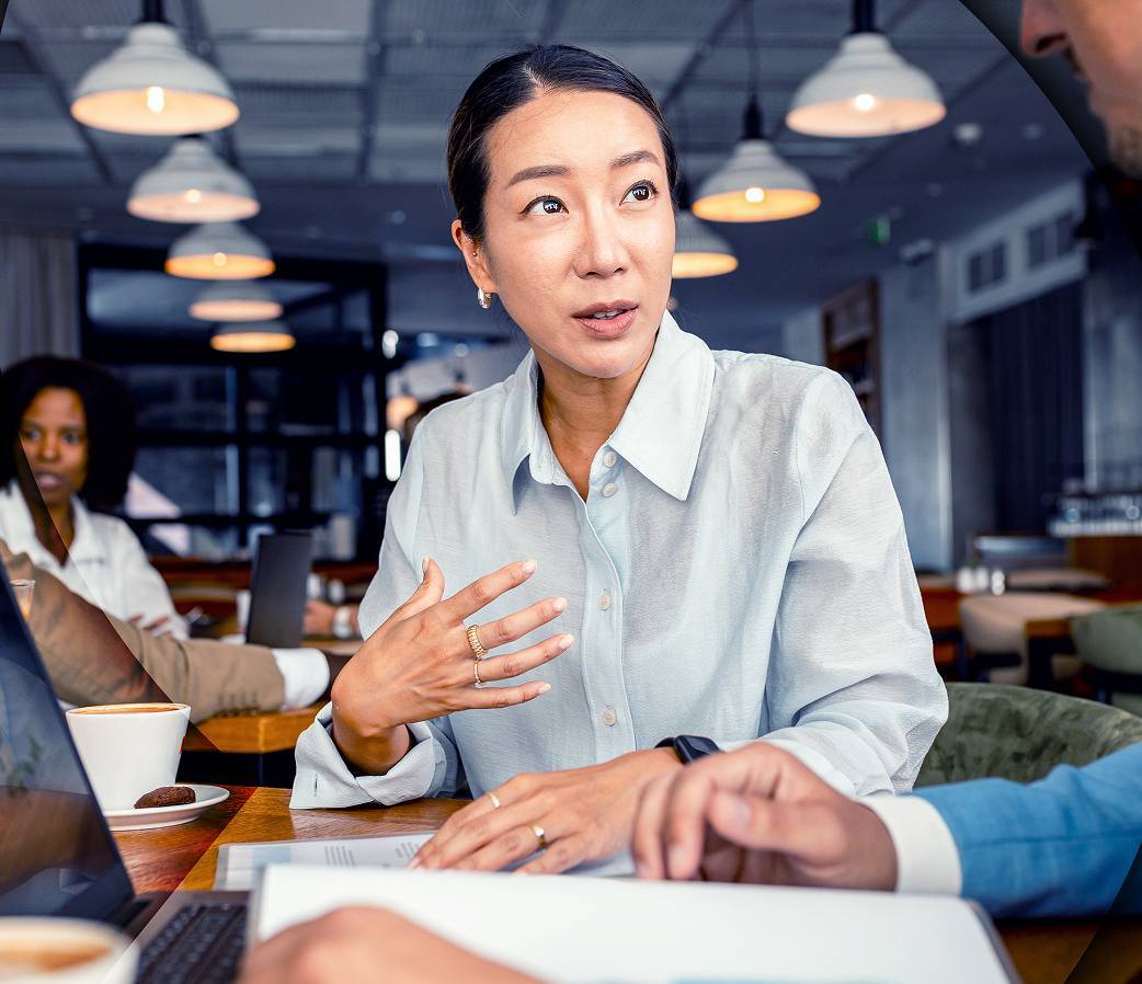 Woman in light shirt talking to man at table