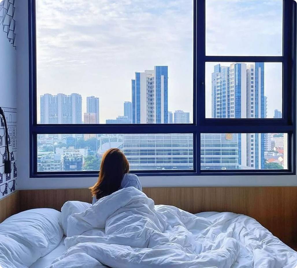 Woman with duvet on top looking at city