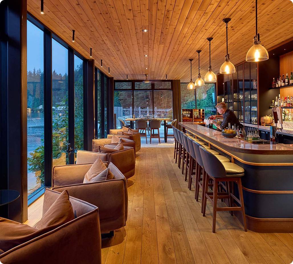 Bartender pouring drinks at warm lit bar area