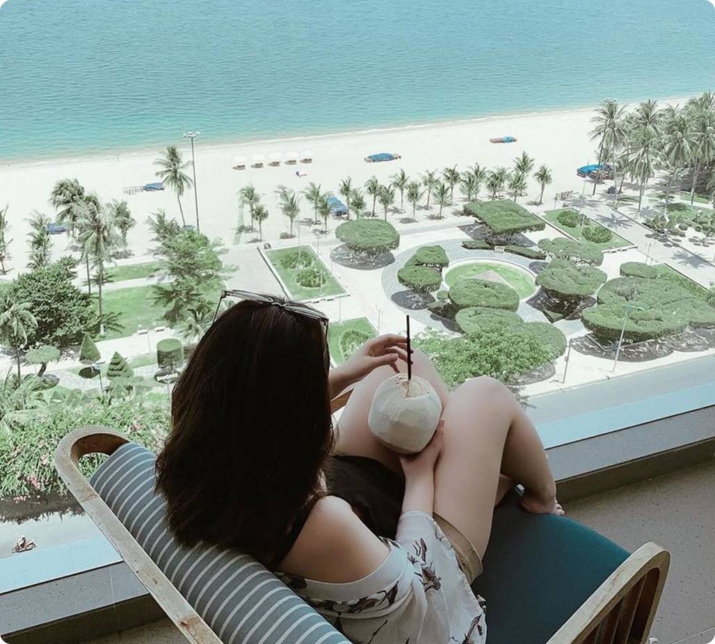 Woman with cup sitting on balcony