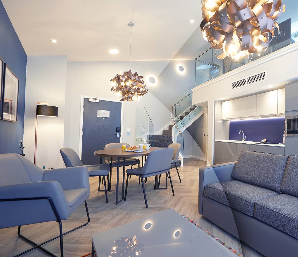 Blue living space with chairs and kitchen area