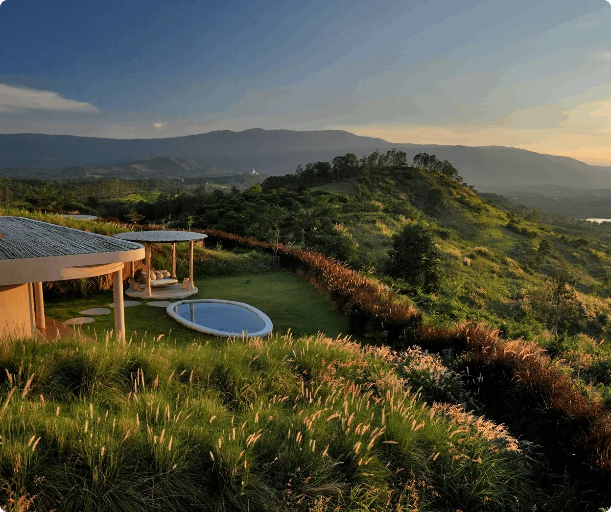 View of huts next to pool in green landscape