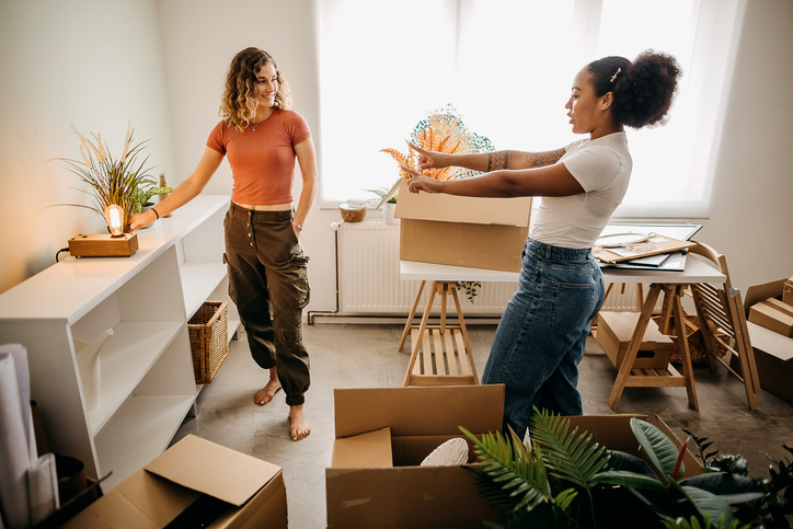 Young people in a flat surrounded by boxes