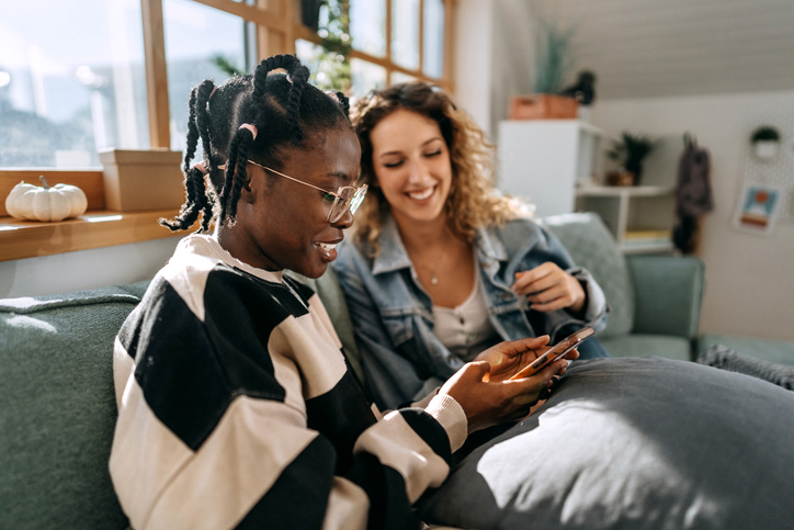 Young people on a couch looking at a phone
